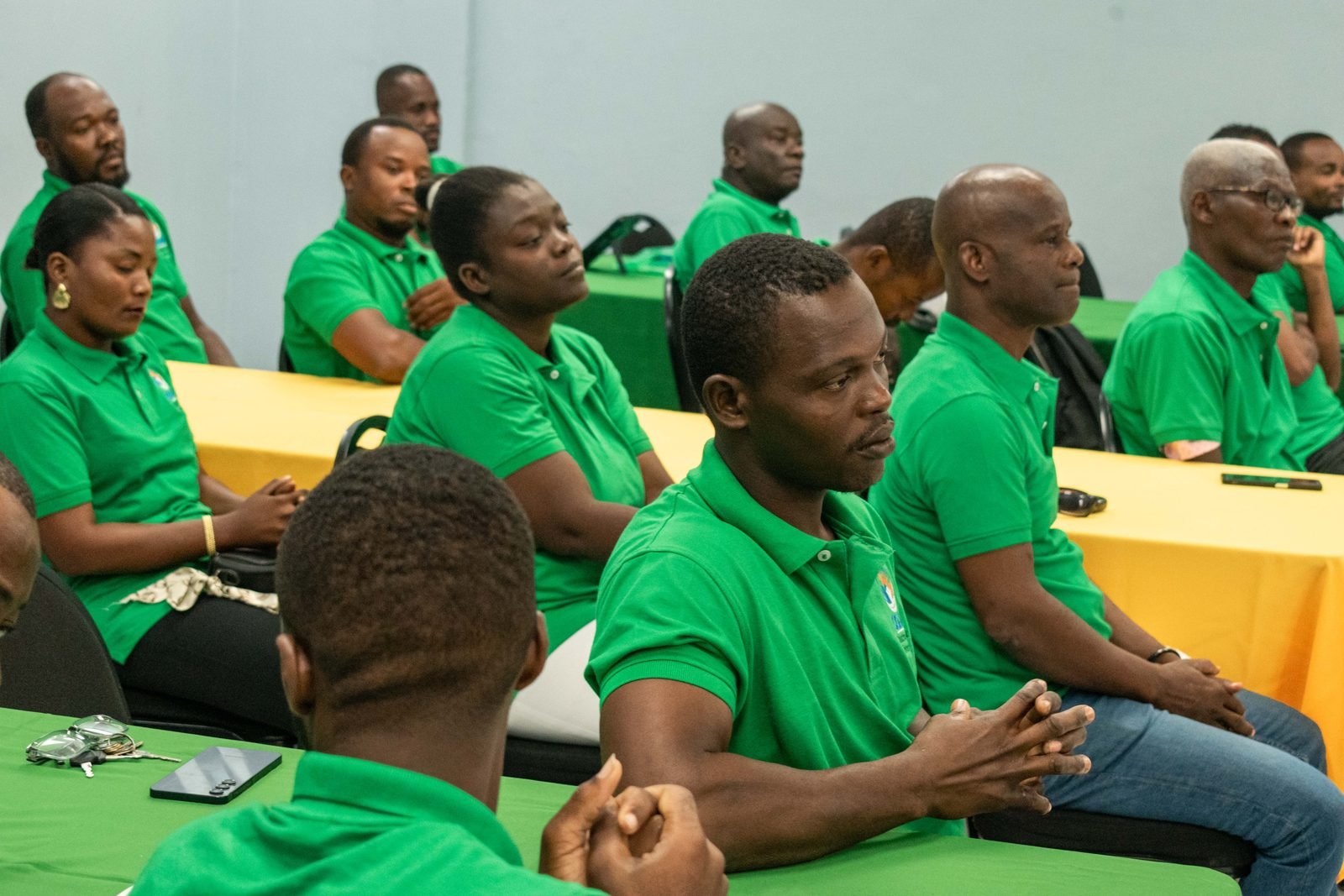 Membres en polo vert à l'écoute pendant une formation